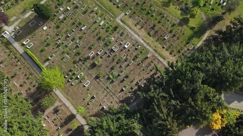 Aerial view of the cemetery in Villa La Angostura, Patagonia, Argentina, surrounded by forest and greenery. The image evokes themes of death, remembrance, religion, spirituality, and peaceful 