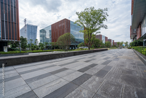 Modern Office Building Entrance with Glass Facade and Landscaped Walkway

