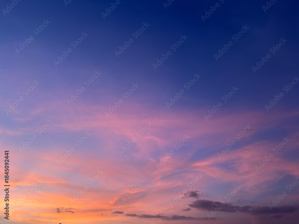 Obraz premium Beautiful twilight sky with pink and purple clouds during sunset, soft gradient colors creating a dreamy and peaceful sky background.