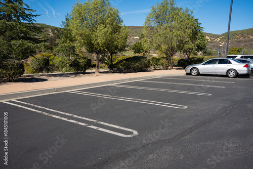 Εκτύπωση καμβά Empty parking lot with a silver sedan parked under a clear blue sky