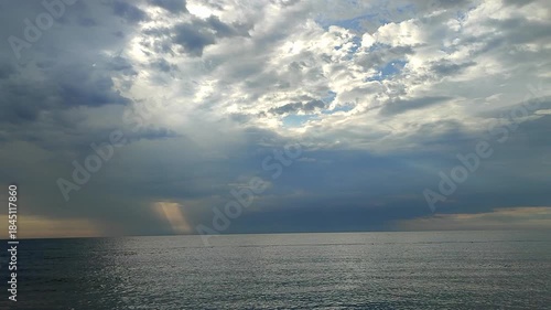 Rain in sea. Rain falling in sea. Cloudy, rainy, stormy weather at sea. Dark rainy clouds over water. Sea, sky, clouds and horizon line. Seascape. Scenery landscape. Nature natural background