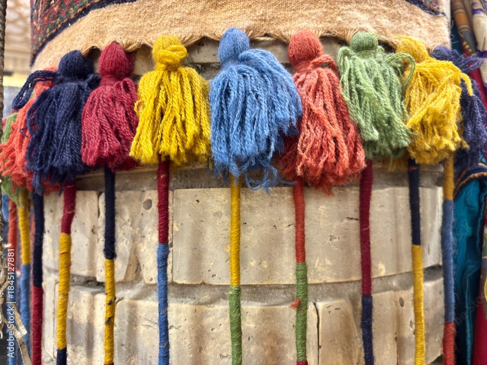 Obraz premium Colorful wool tassels decorating a traditional Central Asian textile.
