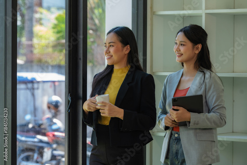 Portrait of two young businesswomen having a meeting or presentation and seminar standing in the office. Portrait of a young businesswoman talking.