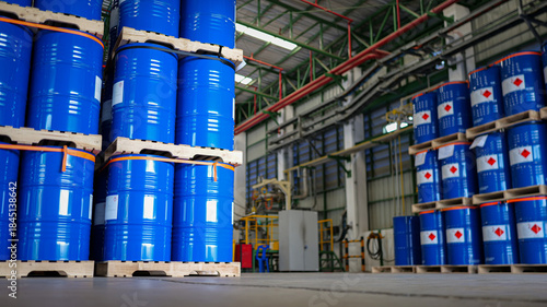 Warehouse stocked with numerous blue steel drums, barrels tank, which are containers used for shipping bulk cargo. chemical storage, warehouse management