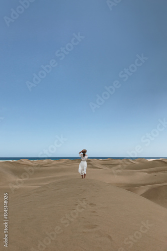 Woman Walking on Sandy Dunes by the Ocean