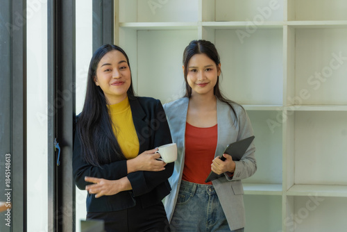 Portrait of two young businesswomen having a meeting or presentation and seminar standing in the office. Portrait of a young businesswoman talking.