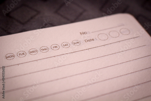 Close up of blank notebook page with day of the week icons, concept of planning and organization.