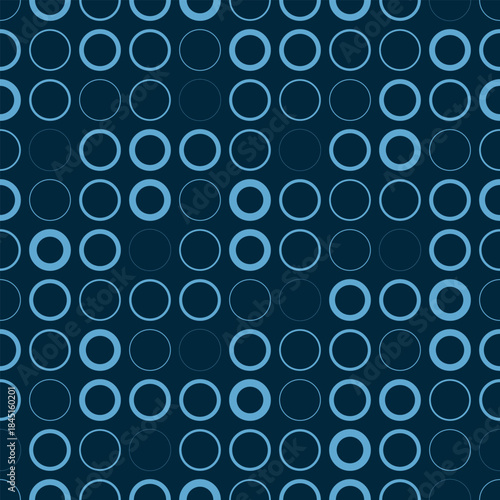 
A seamless pattern of symmetrically arranged light blue circles on a dark blue background. The circles vary in brightness and form an abstract blue pattern. Vector illustration for your projects.