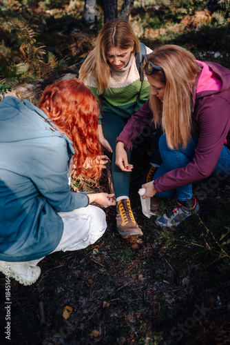 Women hiking giving first aid to an injured friend