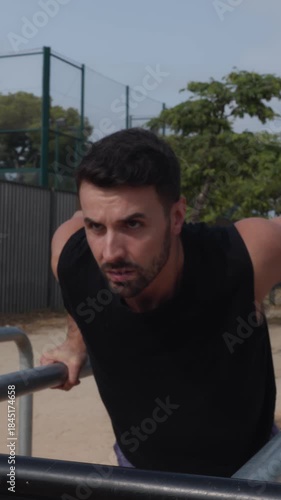 Focused athlete doing triceps dips workout on parallel bars