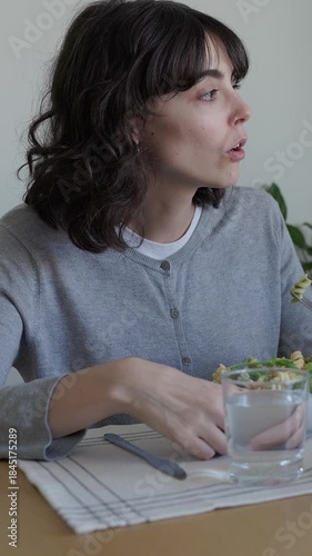 Young brunette woman eating pasta salad lunch