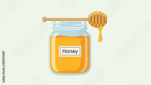 Glass jar filled with golden honey and a honey dipper resting on top with a label in a