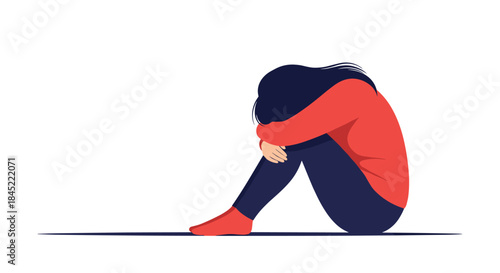 Person sits on the floor with knees drawn up and head resting on arms showing sadness loneliness and a moment of emotional struggle.