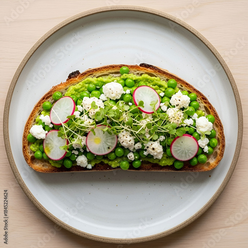 A flat lay of a loaded breakfast toast with smashed peas