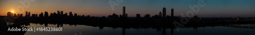 Aerial view of the silhouetted Boston skyline, including the Custom House Tower and Prudential Center, reflecting in the Charles River at dusk, Boston, Massachusetts, United States.