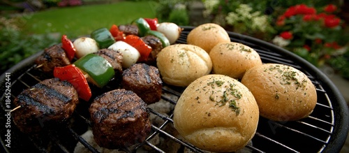 Grilled food with skewers and bread rolls.