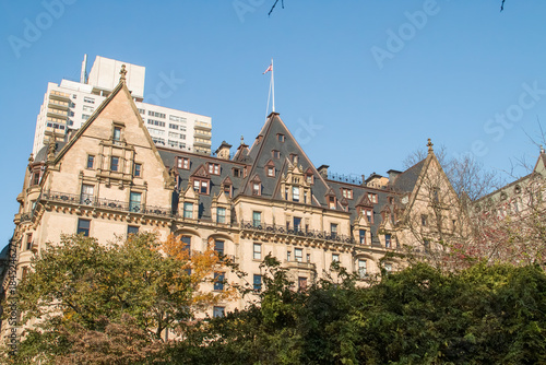 Tejado del edificio The Dakota sobresaliendo sobre los árboles de Central Park, Nueva York, EEUU. Ramas de los árboles de los jardines de Central Park en otoño. Noviembre 2019.