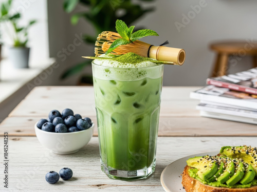 Refreshing iced matcha latte with mint and blueberries, served with avocado toast