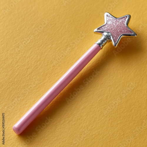 Pink star magic wand with glitter on yellow background.