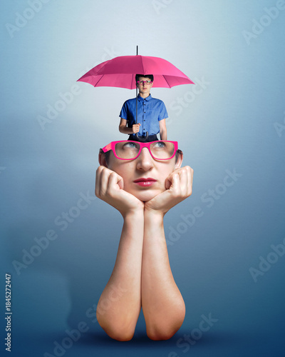 Photography Portrait of a thoughtful woman in glasses with a small copy of herself with an umbrella visible from her head