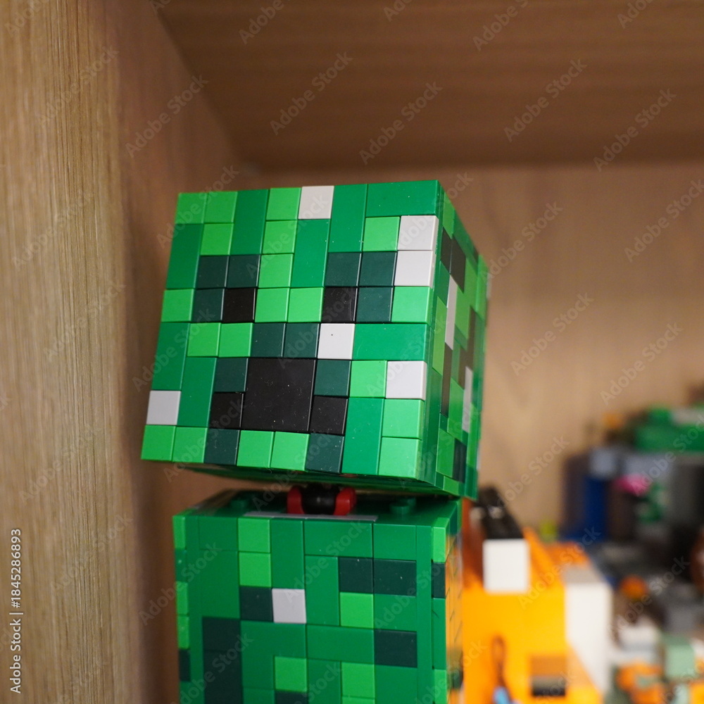 Obraz premium Green pixelated creeper character made from building blocks on a shelf