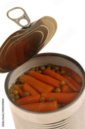 Boîte de conserve ouverte avec des petits pois et des carottes en gros plan sur fond blanc