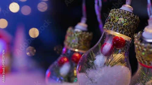Large light bulbs decorated inside against a blurred background of a house and Christmas trees