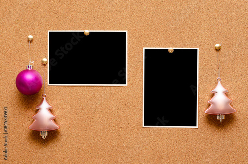 Empty photos and Christmas tree toys are pinned on a cork board. Copy space
