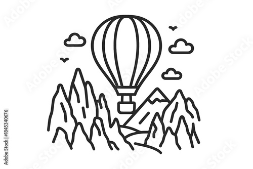 Hot air balloon soaring over jagged mountain peaks and rocky landscape with small clouds