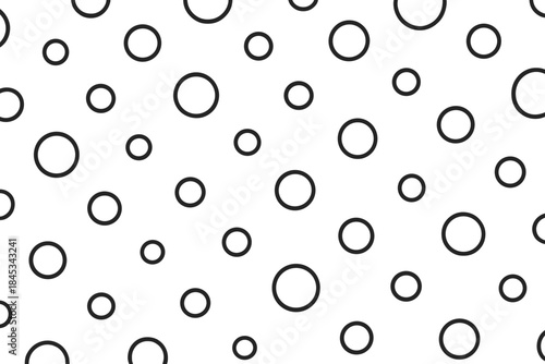 Abstract seamless pattern of scattered black outline circles and rings on a white background