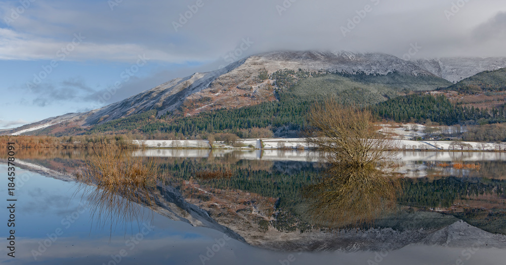 Fototapeta premium Snowy Mountain Reflected in a Still Lake Surface Under a Blue Sky