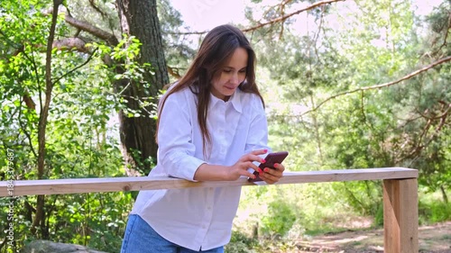 A young pretty woman typing on her smartphone. Slow motion. The concept of modern technology and social networks.
