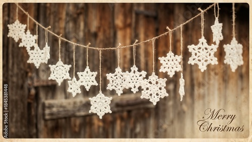 Crocheted white snowflakes hanging on a string with a rustic wooden background for Merry Christmas