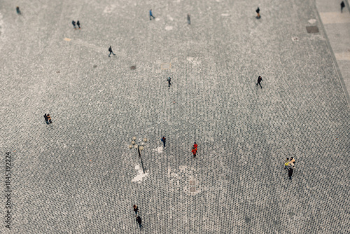 A stunning aerial shot captures a vibrant scene of people walking on a textured surface, creating intriguing patterns in a busy urban environment. Winter snow surface, frost 