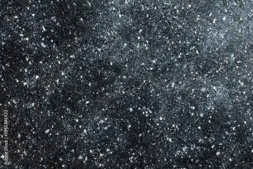 Natural black granite rock surface with mineral speckles texture.