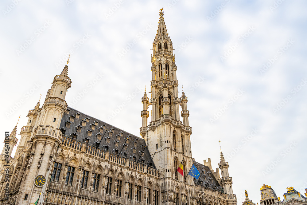 Fototapeta premium Brussels City Hall tower on Grand Place square Belgium Guildhall Building. Old houses architecture building in city center Square. Cityscape landmark