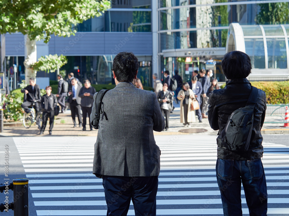 Obraz premium 都心の街の交差点で信号待ちのビジネスマンの姿