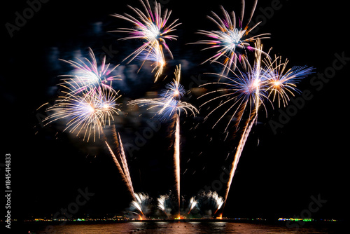 Amazing beautiful colorful firework display over sea on celebration night. Fireworks show for happy new year	