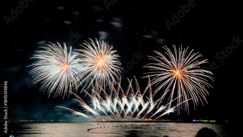 Amazing beautiful colorful firework display over sea on celebration night. Fireworks show for happy new year	
