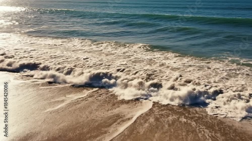 Ocean Waves Crashing on Sandy Beach - A Serene Coastal Scene.