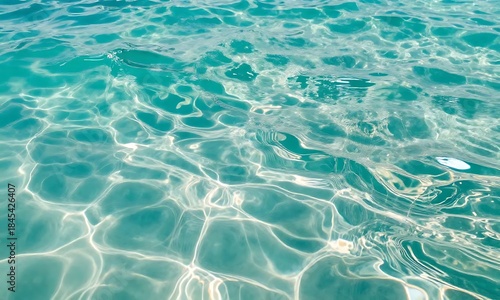 光が差し込む透明なエメラルドグリーンの海面