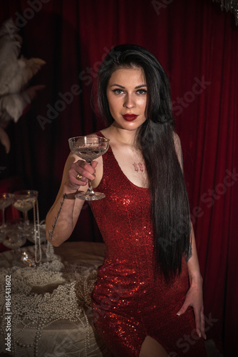Passion brunette woman in shining red fashionable dress in vintage interior