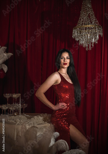 Passion brunette woman in shining red fashionable dress in vintage interior