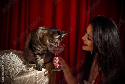 Passion brunette woman in shining red fashionable dress in vintage interior