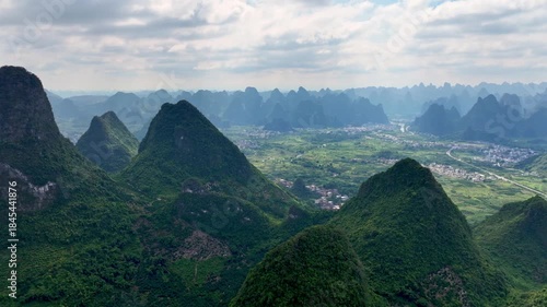 Aerial Drone Views of China Dramatic Mountain Shapes. Bright Green Slopes and Quiet Settlements. Revealing Timeless Beauty and Grand Scale of Beautiful Asian Landscape. Vacation Travel Destination 4k