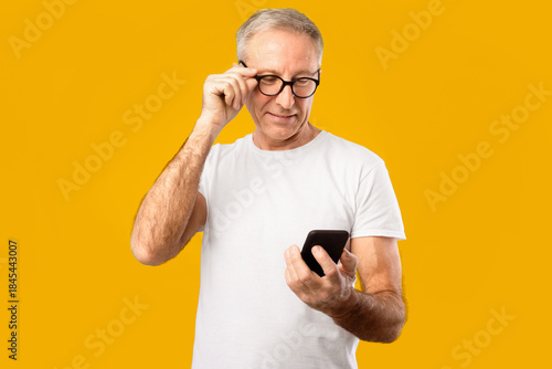 Fotografi A man stands in front of a bright yellow background