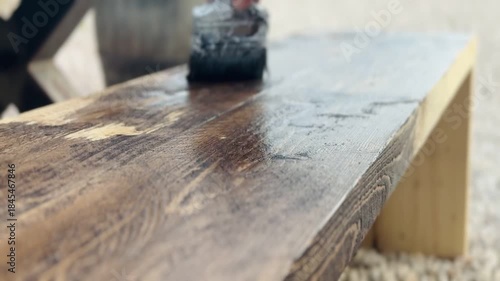 Close-Up of Hand Staining Wooden Furniture With Paint Brush