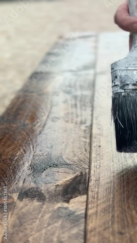 Close-Up of Hand Staining Wooden Furniture With Paint Brush