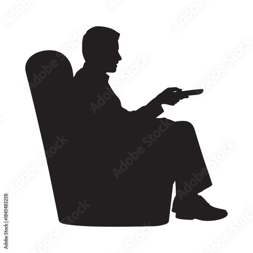A silhouetted man relaxing in an armchair while holding a remote control