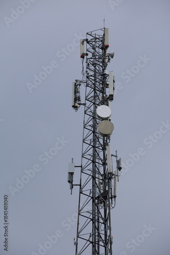 Wireless communication technology uses a steel tower with a cell phone antenna for radio signal transmission to the mobile network in the blue sky